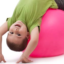 Child plays on large pink ball