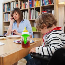 Child and mother sit at table in house